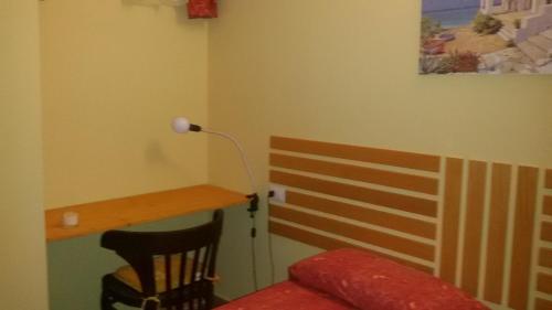 a room with a bed and a desk and a lamp at B&B La villetta rossa in Anzio