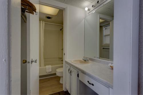 W łazience znajduje się umywalka, toaleta i lustro. w obiekcie EastGate Inn w mieście Littleton