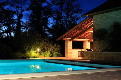a swimming pool in front of a house at night at Maison d'hôtes Saint Alary in Lavaur