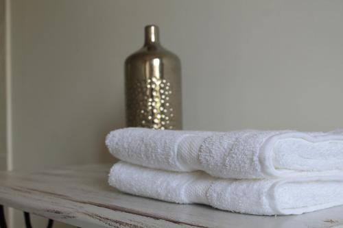 a pile of towels sitting on a table with a bottle at Maison d'hôtes Saint Alary in Lavaur