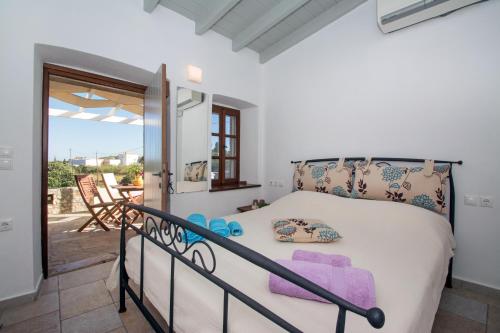 a bedroom with a bed and a balcony at Villa Cerigo in Aroniadika