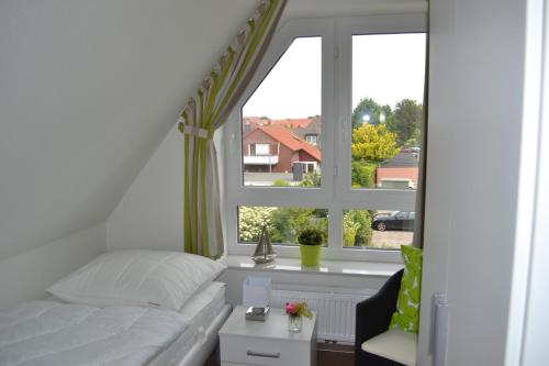 a bedroom with a bed and a large window at Steuerbord in Horumersiel