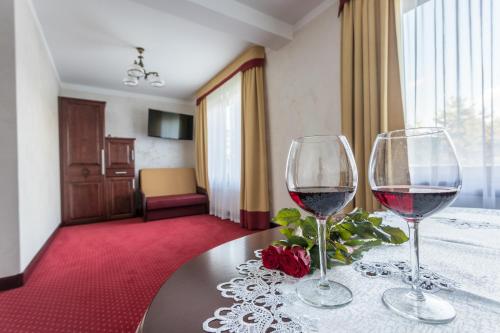 two glasses of wine on a table in a room at Hotel *** Rancho Lot in Nowy Targ