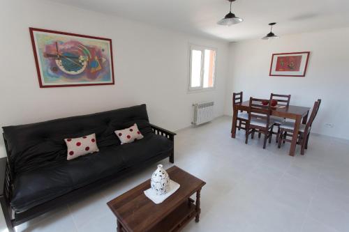 a living room with a black couch and a table at Aparthotel Aldea Termal in Copahue