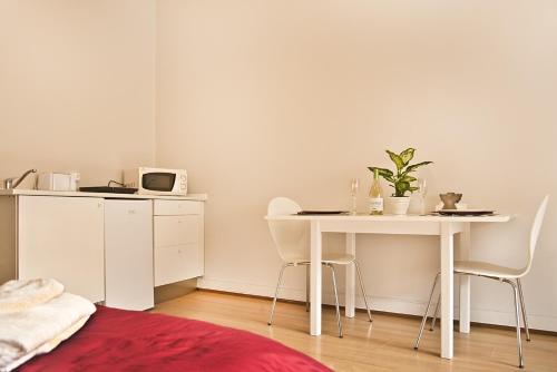 Habitación blanca con mesa, mesa y sillas en VRS - Porto Centre Trindade Studio, en Oporto