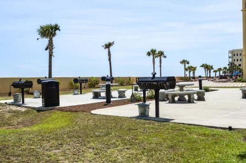 a park with picnic tables and palm trees at Phoenix West II Unit 1109 in Orange Beach