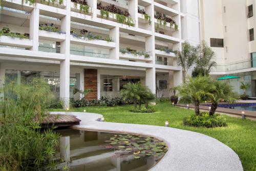 an apartment building with a pond in front of it at Mesón de la Luna Hotel & Spa in Mérida