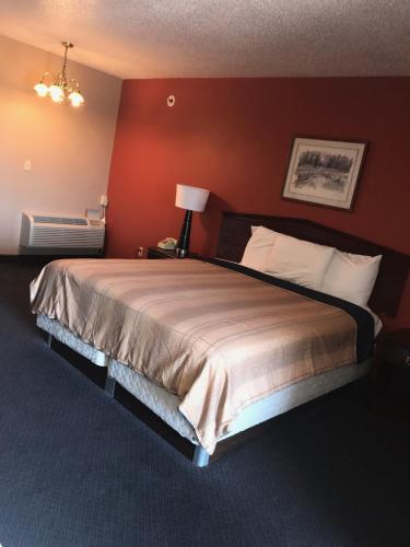 a bedroom with a large bed with a red wall at Red Carpet Inn in Hot Springs