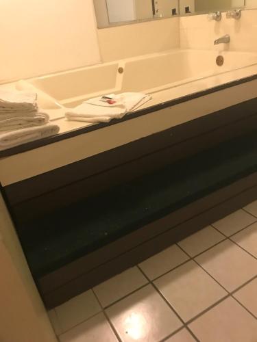 a bathroom with a bath tub and a mirror at Red Carpet Inn in Hot Springs