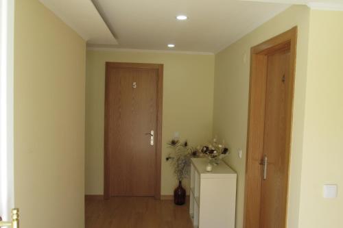 a room with a door and a table with a plant at Residencial Marialva Park in Corroios