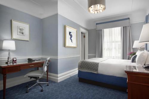 a hotel room with a bed and a desk and a computer at Fairmont Copley Plaza in Boston