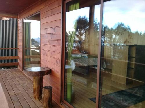 a screened porch with a table and a window at Hotel y Cabañas Terrazas Vista al Mar hct in Ancud