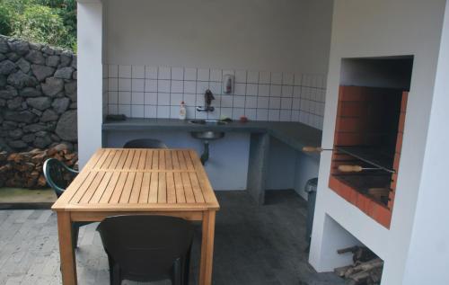a kitchen with a wooden table and a sink at Yes Pico in Santa Luzia