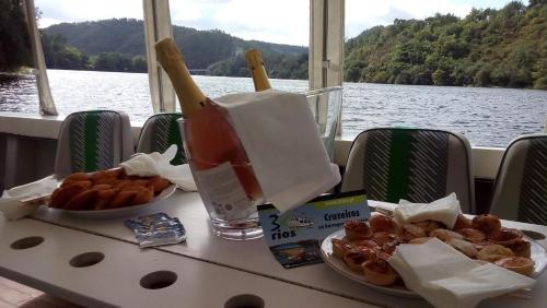 a table with two plates of food on a boat at Hotel Rural Quinta da Conchada in Aguieira