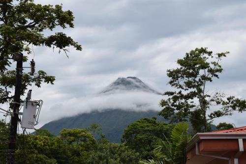 a mountain in the distance with clouds and trees at Hotel La Choza Inn in Fortuna