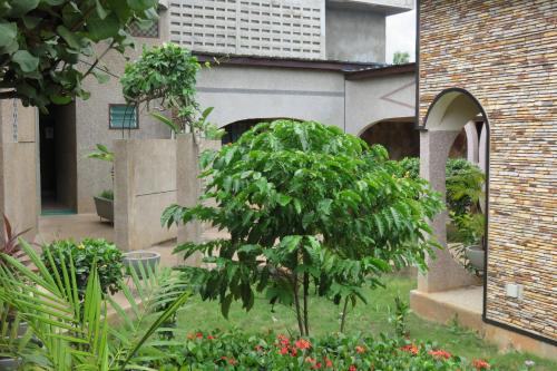 a garden with a tree in the middle of a building at Hotel Agbeviade in Palimé