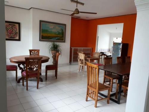 a dining room with wooden tables and chairs at Anggrek Mas Bed & Breakfast in Ubud
