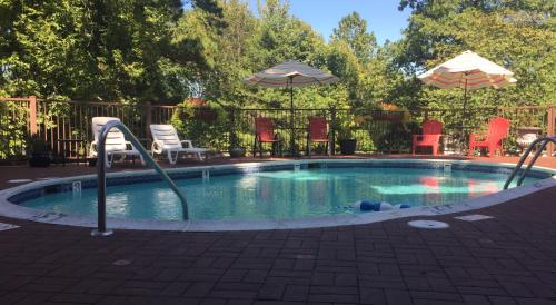 a small swimming pool with chairs and umbrellas at Matterhorn Tower in Eureka Springs