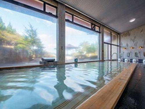 a large indoor swimming pool with a large window at Pals Inn Katsuura in Katsuura