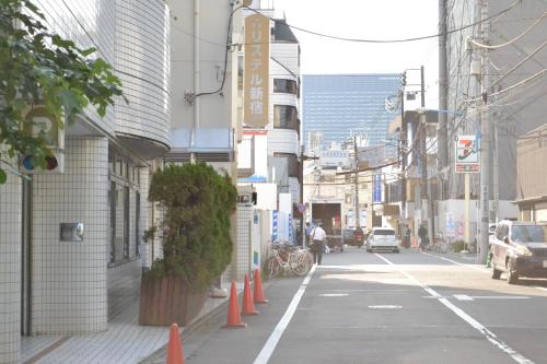 an empty city street with orange cones on the sidewalk at Hotel Listel Shinjuku in Tokyo