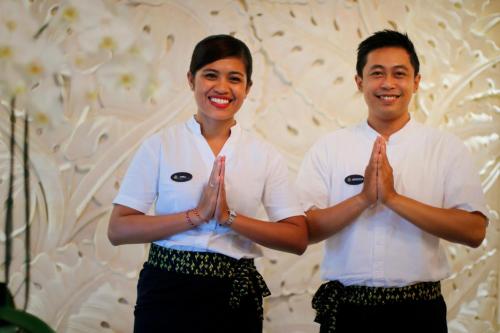 a man and a woman standing in their hands at Royal Tulip Springhill Resort Jimbaran in Jimbaran