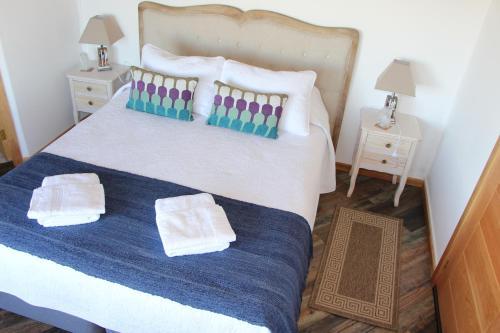 a bedroom with a bed with two towels on it at Hostal Fernando de Magalhaes in Punta Arenas