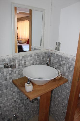 a bathroom with a sink and a mirror at Hostal Fernando de Magalhaes in Punta Arenas
