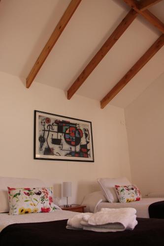 a bedroom with two beds and a painting on the wall at Hostal Fernando de Magalhaes in Punta Arenas