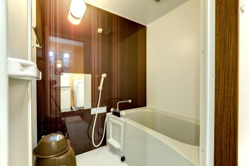 宜野灣的住宿－露台度假8號公寓式酒店，带浴缸和卫生间的浴室。