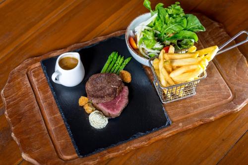 a tray with a steak and fries and a bowl of salad at Crystal Bay Yacht Club Beach Resort in Lamai