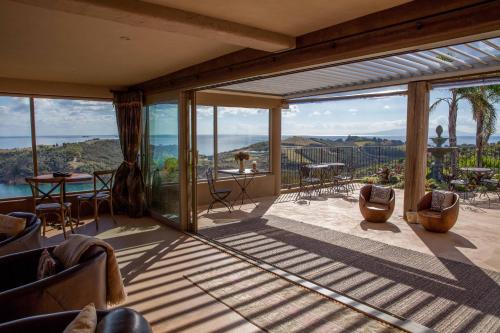 a living room with glass doors and a view of the ocean at Delamore Lodge in Oneroa