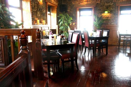 a dining room with tables and chairs in a restaurant at Maddens Bridge Bar & Guesthouse in Bundoran