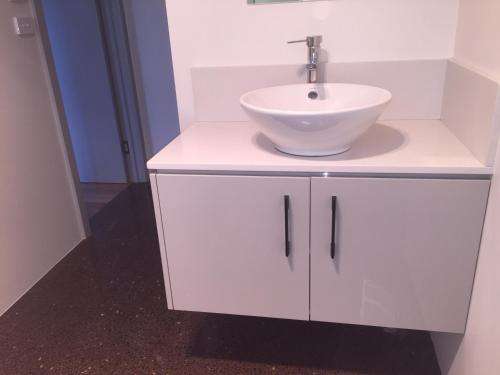 a bathroom with a sink and a white cabinet at Glenaire apartments at Pontifex in Strahan