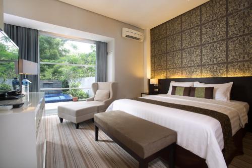 a hotel room with a large bed and a window at Grand Kecubung Hotel in Pangkalan Bun