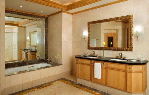 a bathroom with two sinks and a mirror at Grand Hyatt Muscat in Muscat