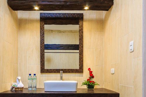 y baño con lavabo y espejo. en Casa Mia Hotel, en Antigua Guatemala