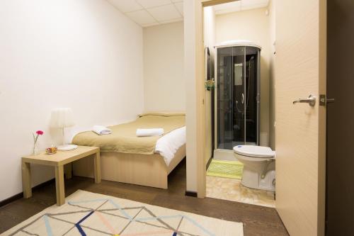 a bathroom with a bed and a toilet in a room at Z Hostel in Irkutsk