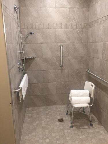 uma casa de banho com um chuveiro e uma cadeira. em Canyon Country Lodge em Escalante