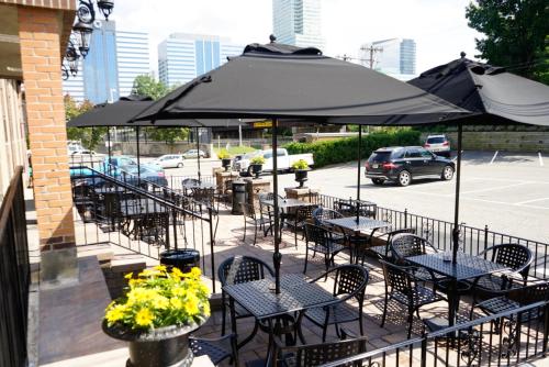 a group of tables and chairs under an umbrella at Holland Hotel Free Parking Jersey City in Jersey City