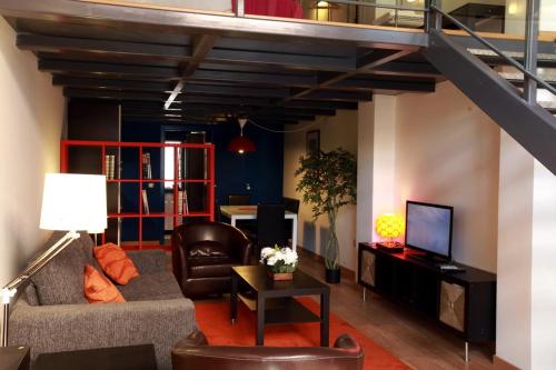sala de estar con sofá y TV en Marina Loft & Apartments, en Valencia