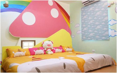 una camera da letto con un letto con un arcobaleno e animali di peluche di Zoo B&B a Città di Taitung