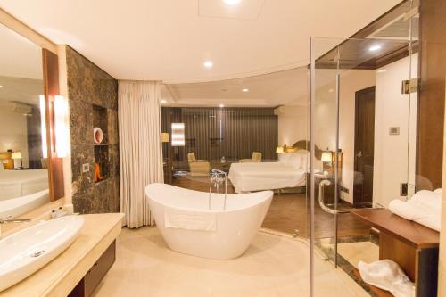 a bathroom with a bath tub and a sink at Sai Gon Ha Long Hotel in Ha Long