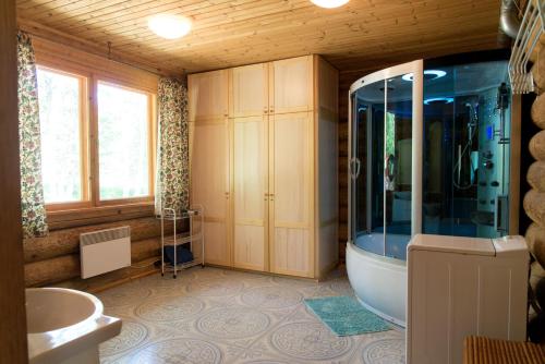 La salle de bains est pourvue d'une douche, d'une baignoire et d'un lavabo. dans l'établissement Guest House Lēveri, à Valgalciems