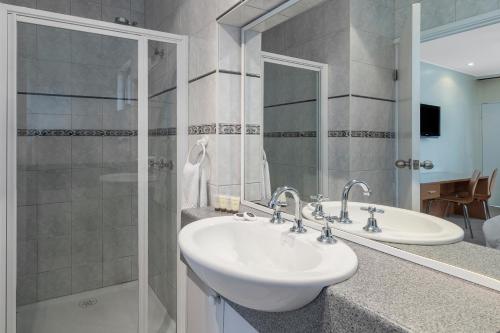 a bathroom with a sink, mirror, and bathtub at Best Western Governor Gipps Motor Inn in Traralgon