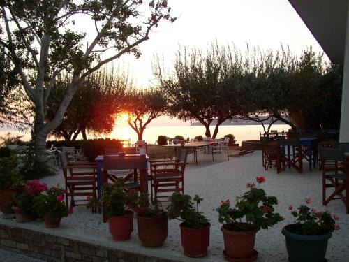 a patio with tables and chairs and flowers in pots at Hotel Votsala in Pyrgi Thermis