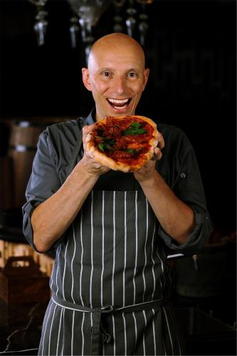 a man holding a large slice of pizza at Artyzen Habitat Dongzhimen Beijing in Beijing