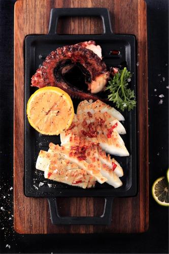 a plate of food with fish and meat and lemon at Artyzen Habitat Dongzhimen Beijing in Beijing