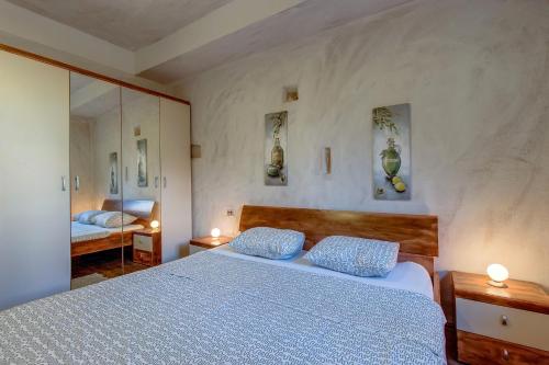 a bedroom with a bed with two pillows on it at Apartments Popi in Mali Lošinj