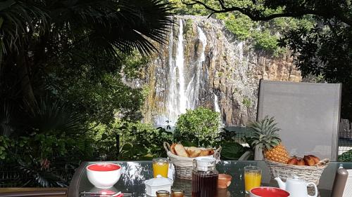 a table with baskets of bread and a waterfall at Les Terrasses de Niagara in Sainte-Suzanne