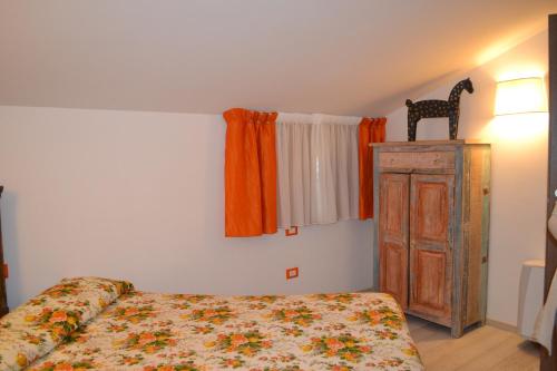 
a bedroom with a bed and a dresser at La Maga del Lago in Scanno
